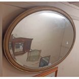 A vintage gilt framed bevelled oval wall mirror with later finish