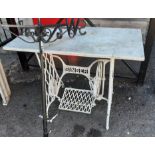 A Singer sewing machine table base with marble top and white painted finish
