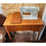 A vintage Singer 413 table sewing machine with teak effect cabinet