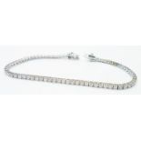 A marked 18K white metal tennis/in line bracelet, each of the links set with an individual small