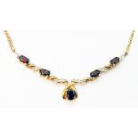 An import marked 375 gold pendant necklace, set with oval garnets and tiny diamonds - matching