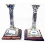 A pair of 7" silver corinthian column candlesticks with detachable nozzles - converted into table