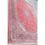 A large Iranian Kashan wool carpet of typical profuse floral design - 427cm X 295cm - moth damage