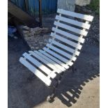 A slatted garden chair with wrought iron frame