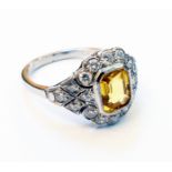 A marked PLAT white metal Art Deco style ring, set with central oblong yellow sapphire within a