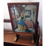 A 20th Century stained mixed wood tilt-top firescreen/tea table, with woolwork panel under glass