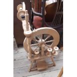 A modern New Zealand blonde wood spinning wheel by Ashford with three additional spindles
