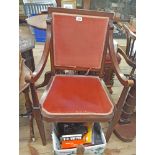 An Edwardian walnut and strung panel back elbow chair with swept armrests and remains of velour