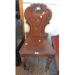 A Victorian mahogany shield back hall chair with C-scroll decoration and moulded seat, set on turned