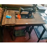 An old Singer treadle sewing machine with oak table top and drawers containing attachments and other