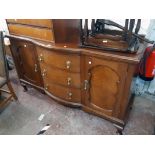 A 5' 7" Edwardian mahogany break bow front sideboard with three central drawers and flanking