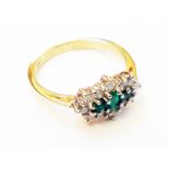 A hallmarked 750/18K 1920`s style ring, set with three emeralds within a diamond encrusted border