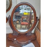 A Victorian mahogany framed swing dressing table mirror with oval plate, set on carved scroll