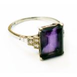 A marked 18/Plat Art Deco ring set with large central emerald cut amethyst with tiny diamonds to
