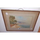 John Shapland: a gilt framed watercolour depicting a view of a beach with a town in the background -