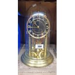 A 20th Century Hermle anniversary clock with black dial and Arabic numerals under glass dome