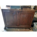 A 3' 11" late Victorian mahogany sideboard with two doors enclosing slides and shelves, rounded