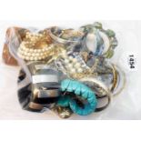 A bag containing a quantity of assorted costume jewellery including numerous bangles, etc.