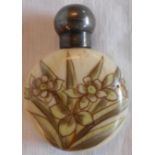 A late Victorian porcelain scent bottle of flat spherical form with floral decoration and silver top