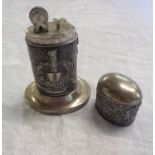 An antique white metal table lighter with eagle over a book motif within ornate decoration