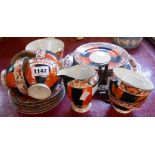 A Czechoslovakian lustre porcelain tea set in the Art Deco style, decorated with orange and black