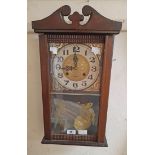 A late 20th Century polished wood cased wall clock with visible pendulum and thirty one day gong