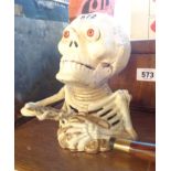 A cast iron skeleton money box