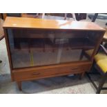 A 3' 6" retro teak effect book cabinet with adjustable shelf enclosed by a pair of glass sliding