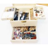 A cream coloured concertina jewellery box containing a quantity of costume and other jewellery, also