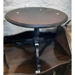 A 24" diameter figured walnut topped low pedestal table, set on ebonised turned pillar and tripod