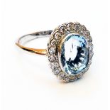 A marked PLAT white metal ring, set with large central oval aquamarine within a diamond encrusted