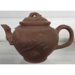 A 20th Century Chinese Yixing zishi terracotta teapot with prunus decoration