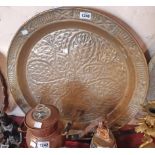 A large brass tray with embossed leaf and cross decoration