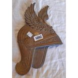 A vintage cast brass wall plaque in the form of a winged helmet - serial number to reverse