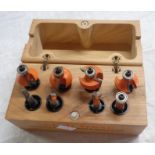 A CMT eight piece router bit set in wood box