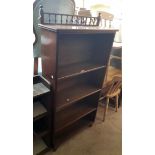 A 29" Edwardian mahogany and mixed wood four shelf open bookcase with spindle top rail and