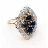 A halmarked 750 gold marquise panel ring, set with four dark blue sapphires within a diamond