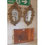 A pair of small reproduction Rococo style cast and brassed metal framed ornate wall mirrors with