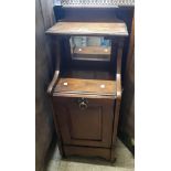 A late Victorian oak coal perdonium with mirror set shelf top and panelled fall-front - damage