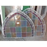 Two stained and leaded glass window panels with arched tops - some damage