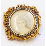 A 3.5cm antique French high carat ornate brooch with pierced floral scroll decoration and central