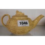 A 19th Century Wegdwood cane ware relief moulded teapot in the Rococo style with spaniel finial to