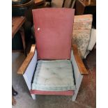 A 1930`s stained and painted wood framed reclining armchair with hardboard sides and remains of