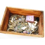 A small vintage wooden crate containing a quantity of assorted vintage white paste and other costume