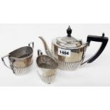 A silver three piece bachelor's tea set of semi-reeded oval design - Sheffield 1900