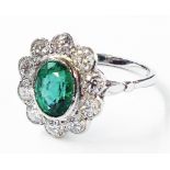 A marked PLAT white metal ring, set with central oval 1ct. emerald within a ten stone diamond border