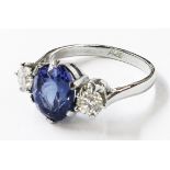 A marked PLAT white metal ring, set with large central oval tanzanite flanked by two brilliant cut