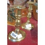 A pair of antique brass ejector candlesticks