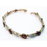 An import marked 375 gold fancy-link bracelet, set with oval garnets and tiny diamonds - matching