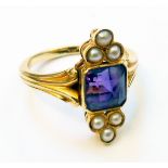 An Edwardian style yellow metal ring, set with central amethyst and six flanking seed pearls